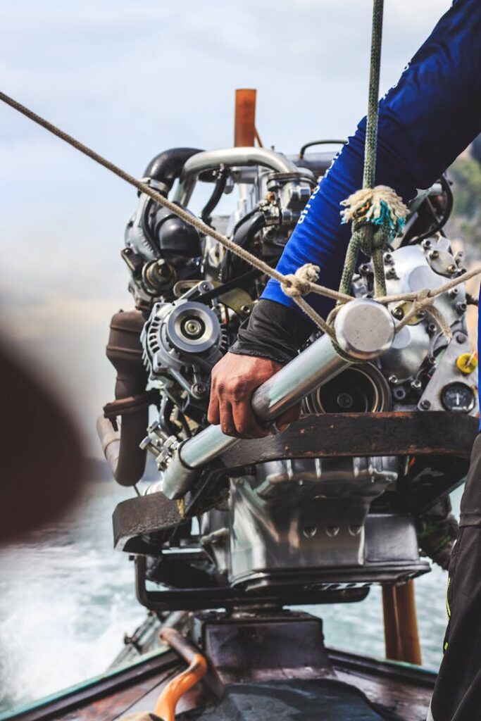 A detailed shot of a boat engine being operated by a person on a watercraft.